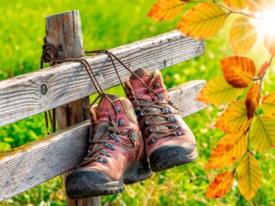 A pair of Walking boots are tied to a fence. The hikers have decided to pamper themselves after a long day! The Outdoor Guide, your place to learn and liberate in nature